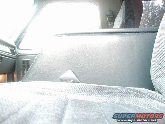 Interior of a vehicle showing passenger seat, console, and window.