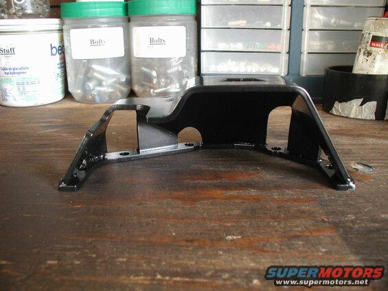 Black metal bracket with mounting holes on a wooden workbench.