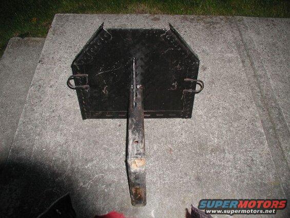 Black metal grill or cooking grate with a handle on concrete