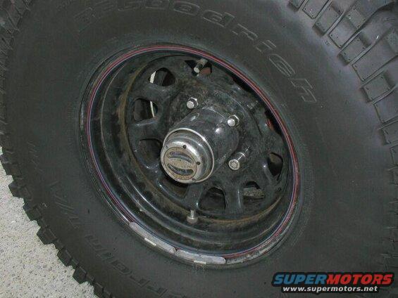 Close-up of a BFGoodrich All-Terrain T/A tire and black steel wheel with chrome hubcap.