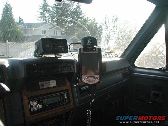 Interior of a vehicle dashboard with GPS, car stereo, and gauge cluster.