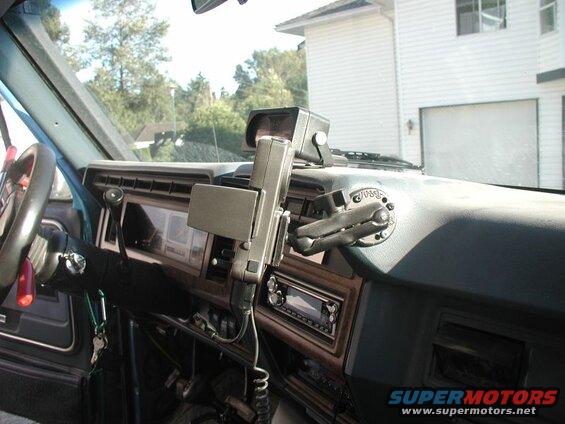 Interior of a vintage Ford Bronco dashboard with a mounted device and radio.