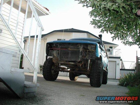 1985 Ford Bronco with large tires and snorkel parked in driveway.