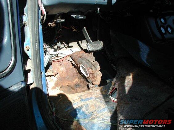 Here is what is left of the drivers side floor.I already had a patch where the dimmer switch was, but now I'll have to make a larger patch. I spent about 15 minutes scraping all the dirt and debrit out of there. You can see the two holes where dirt got in; why did Ford leave such large holes?????
