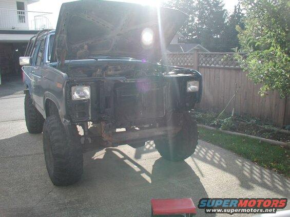 1985 Ford Bronco with hood open, grille removed, and large tires.