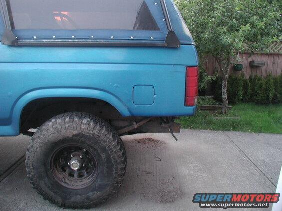 Blue SUV rear quarter panel and off-road tire.