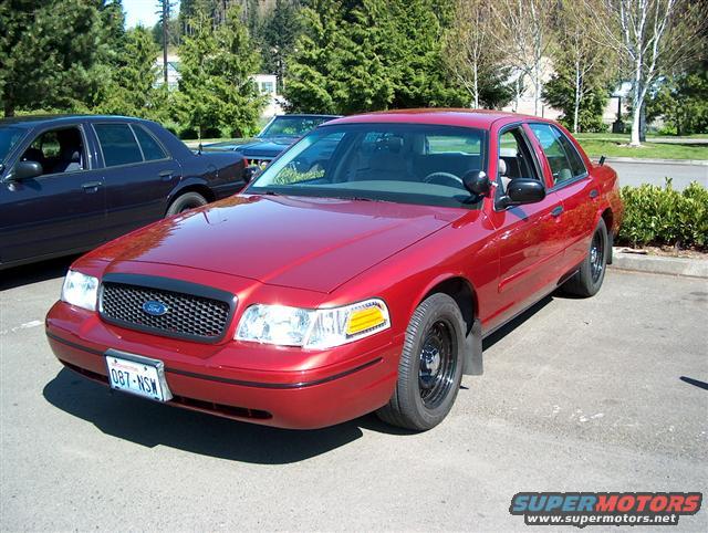 Red 2001 Ford Crown Victoria front 3/4 view with black wheels and license plate 087-NSW