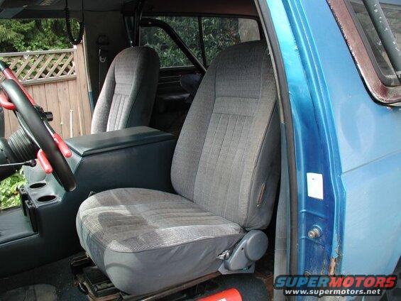 Interior of a blue Ford Bronco showing driver's seat, center console, and steering wheel.