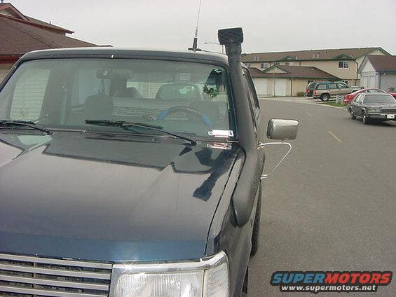 Dark blue SUV with snorkel intake, parked on a residential street.