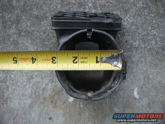 Yellow measuring tape across black plastic drain pipe opening, measuring 3.5 inches.