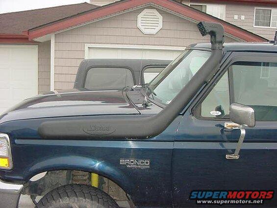 Side view of a dark blue Ford Bronco with a snorkel.