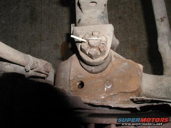 Rusted automotive ball joint with cotter pin on vehicle suspension.