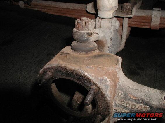 Close-up of a rusty automotive spindle/knuckle with a ball joint and stamped numbers.