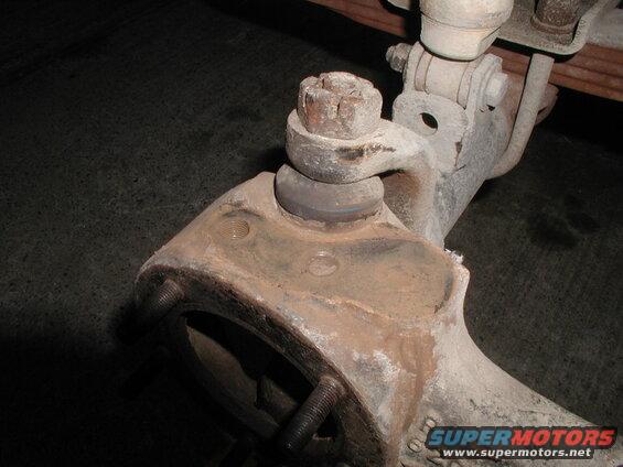 Close-up of rusty vehicle suspension ball joint assembly.
