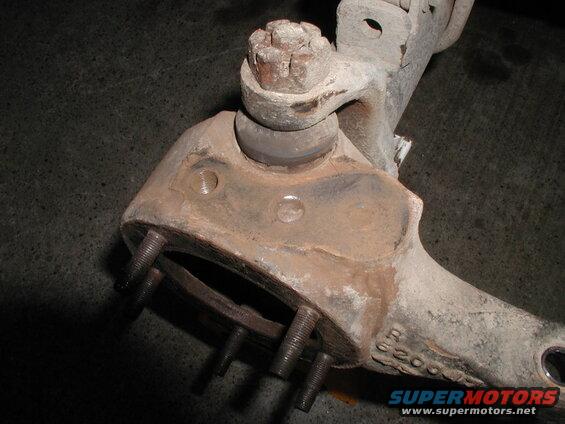 Rusty vehicle suspension part with bolts and markings 'R 62003'.