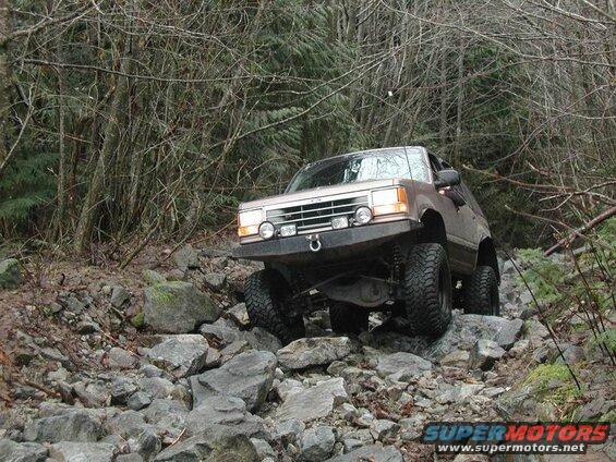 Lifted 1980s Ford Bronco on a rocky trail.