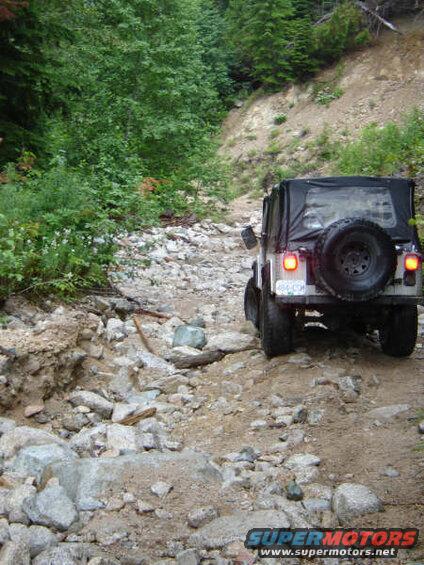 White Jeep Wrangler on a rocky off-road trail.