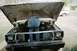 1978 Ford Bronco - A person is working on the engine of a vehicle with its hood open, while another vehicle is visible in the background.