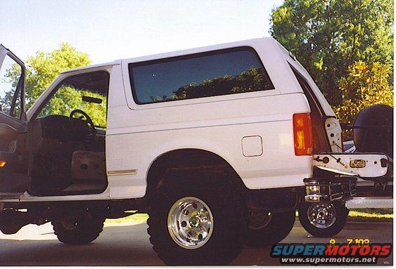 White 1994 Ford Bronco with doors open, showing interior and rear spare tire mount