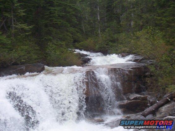 Waterfall in a forest with rocks and trees.