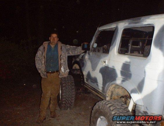 Camouflage SUV side view with a man standing next to it