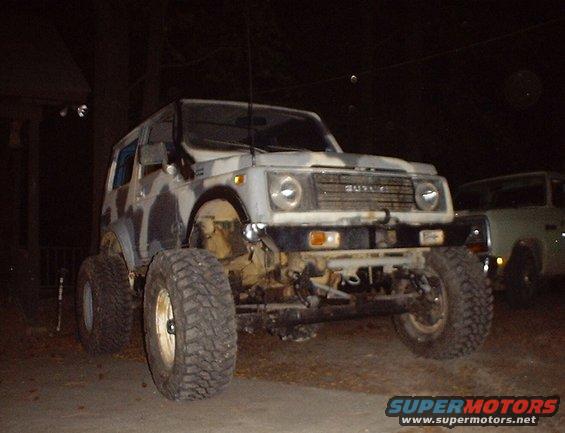 Suzuki Samurai with camouflage paint and large tires, front view