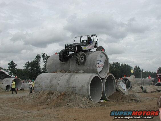 Custom off-road buggy on concrete pipes at an obstacle course.