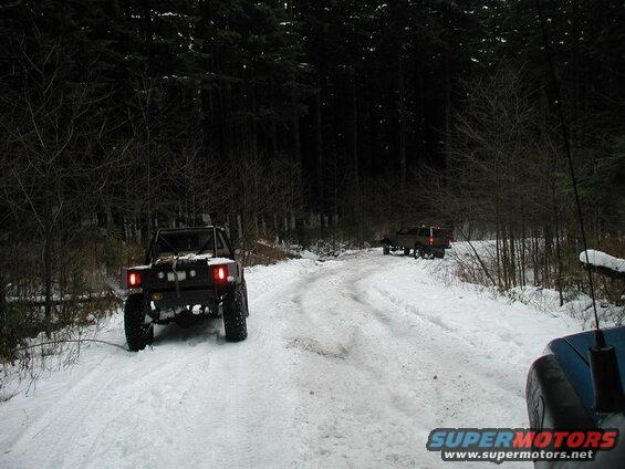 Off-road vehicles on a snowy forest road.
