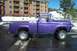 1959 Ford F-100 - A purple 1959 Ford F-100 pickup truck is parked on a wet surface with snow in the background.