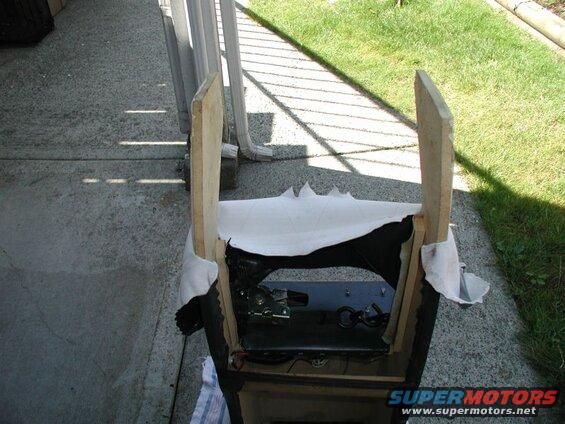 Partially constructed wooden frame with white fabric and visible mechanical parts.