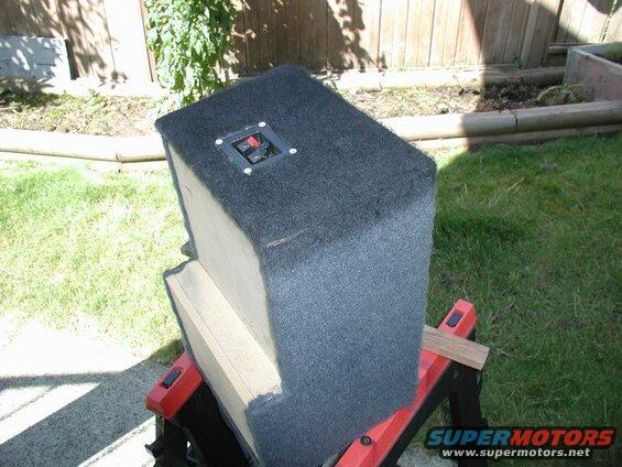 Black carpeted speaker box with terminal cup on sawhorse