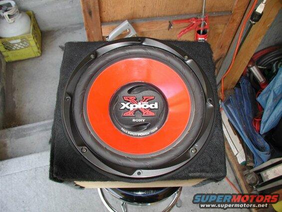 Sony Xplod subwoofer with orange cone in a black enclosure.