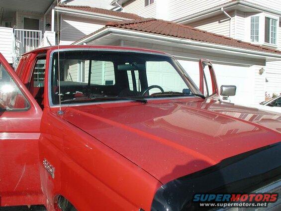 Red Ford F-250 pickup truck, passenger side front view, door open, parked in front of house.
