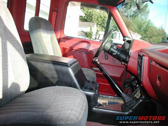 Interior of a red Ford F-250 pickup truck showing a custom black center console and shifter.