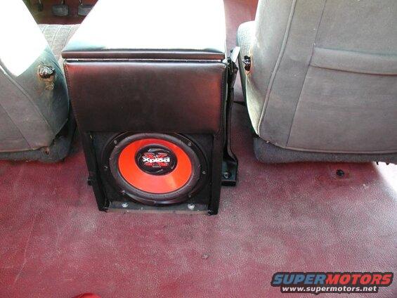 Subwoofer box with Sony Xplod speaker between vehicle seats.