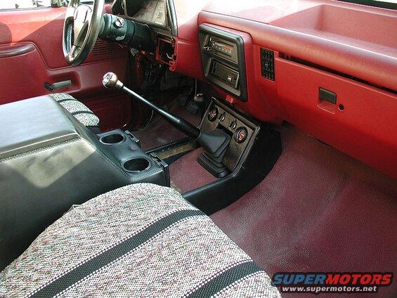 Interior of a pickup truck showing dashboard, center console, shifter, and seats.