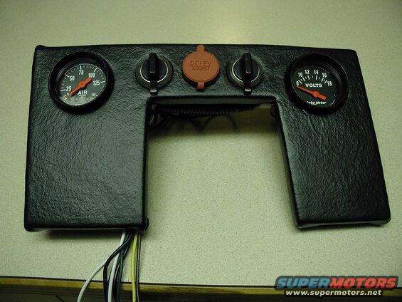 Custom dashboard panel with gauges, 12V socket, and switches.
