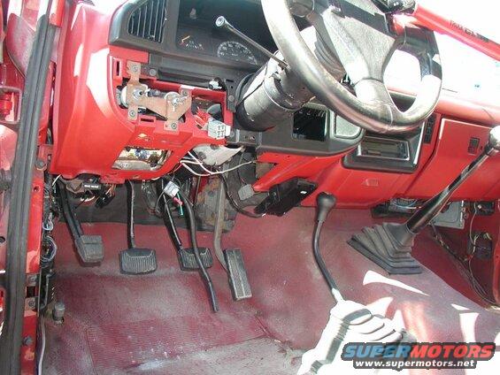 Interior of a red Ford F-250 truck showing dashboard, steering wheel, and manual transmission.