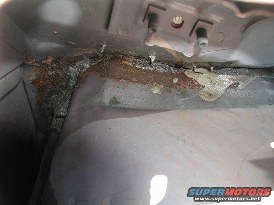Underside of a vehicle with rust and a yellow substance