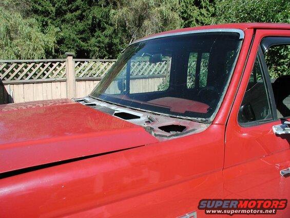 Red Ford F-250 pickup truck, front passenger side, hood and windshield area, windshield removed.