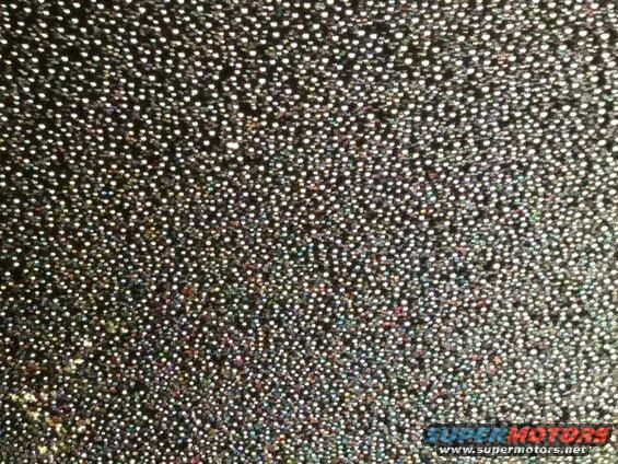 Black fabric with a glittery, speckled pattern of small, reflective dots.