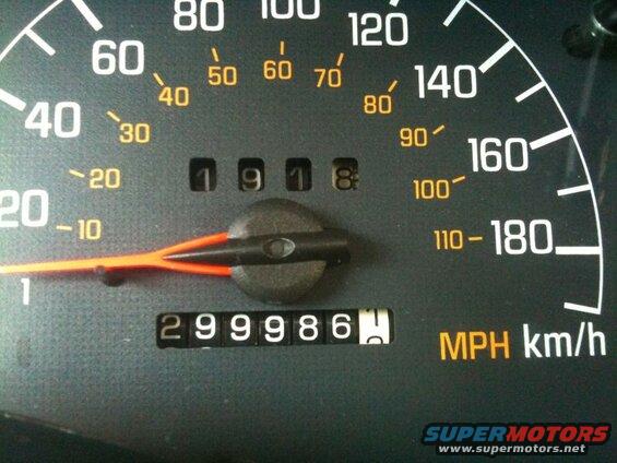 Car dashboard showing speedometer and odometer reading 299986.