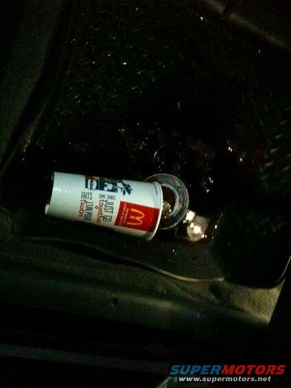 McDonald's cup on its side on a wet surface.