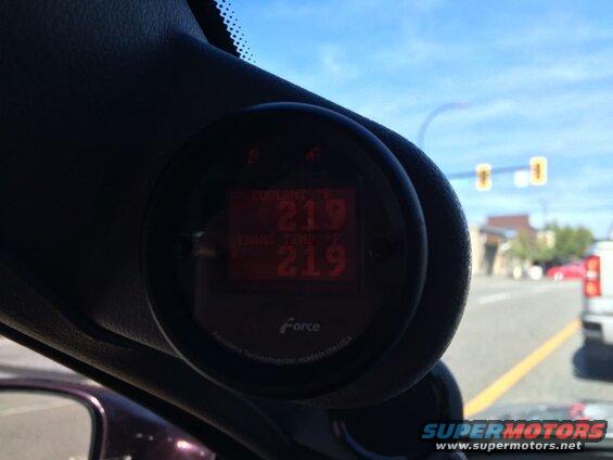 Digital gauge showing 219 F for coolant and transmission temperature inside a vehicle.