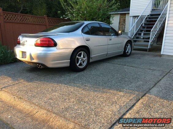 Silver 2002 Pontiac Grand Prix, rear driver's side view, parked on concrete driveway.