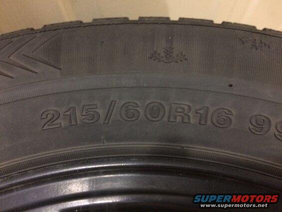 Close-up of a tire sidewall showing size 215/60R16 99 and a snowflake symbol.