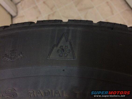 Close-up of a tire sidewall with a snowflake symbol and "RADIAL TUBELESS" text.