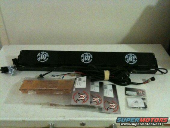 Black Rigid Industries LED light bar with accessories on a white table.