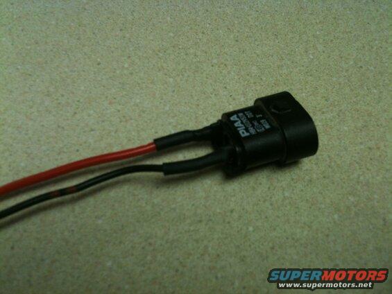 Black electrical connector with red and black wires, labeled PIAA.