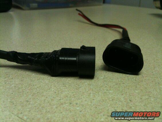 Close-up of two black electrical connectors on a speckled surface.